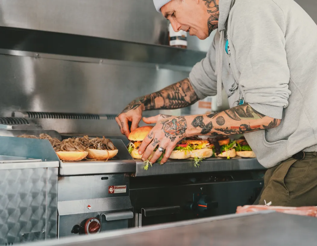 Bernd Müller bereitet frische Burger im Foodliner-Foodtruck zu – erstklassige Street-Food-Erlebnisse in Mannheim und Heidelberg.
