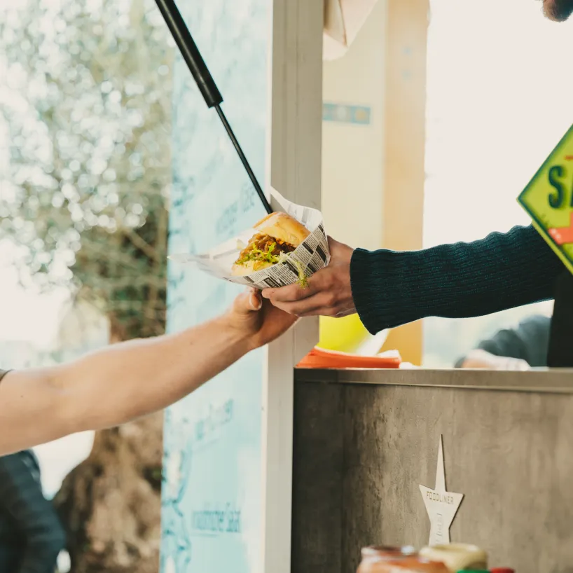 burger wird vom foodtruck übergeben